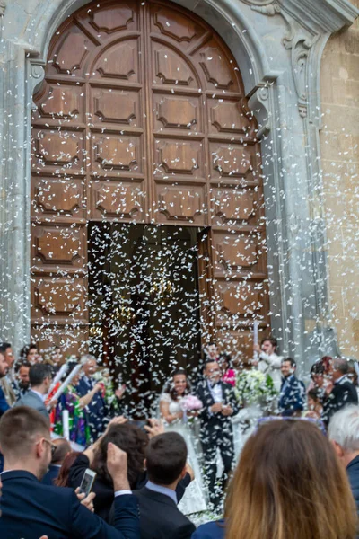 May 25, 2019, Marsala, Italy, Italian catholic wedding in church with many happy guests and salute from papers and rice