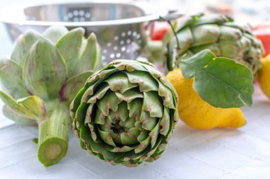 Enginar fidanlığından taze taze çiğ enginar çiçekleri, Yunanistan, Argolida 'da yeni hasat, taze limonla pişirmeye hazır.