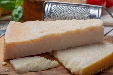 Orijinal İtalyan peyniri, yıllanmış parmesan inek sütü peyniri, Parmigiano-Reggiano parçaları yakın plan.