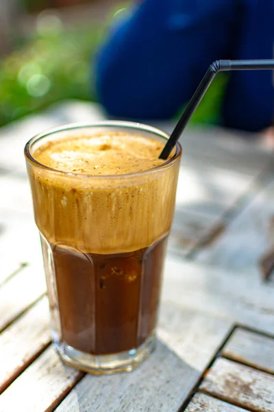 Traditional greek cold coffee Frappe with foam made from water, instant coffee and ice cubes in glass close up
