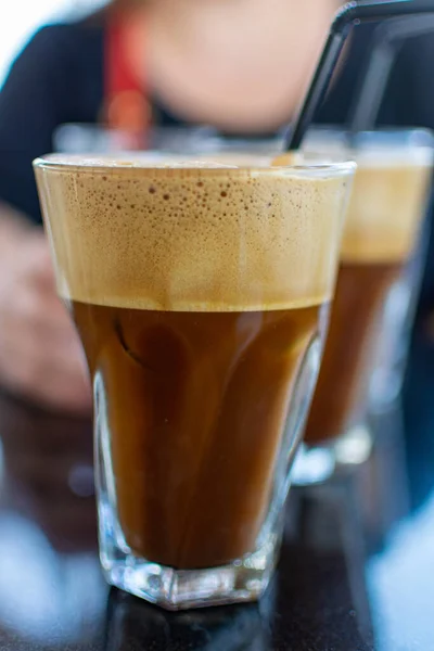 Traditional greek cold coffee Frappe with foam made from water, instant coffee and ice cubes in glass close up