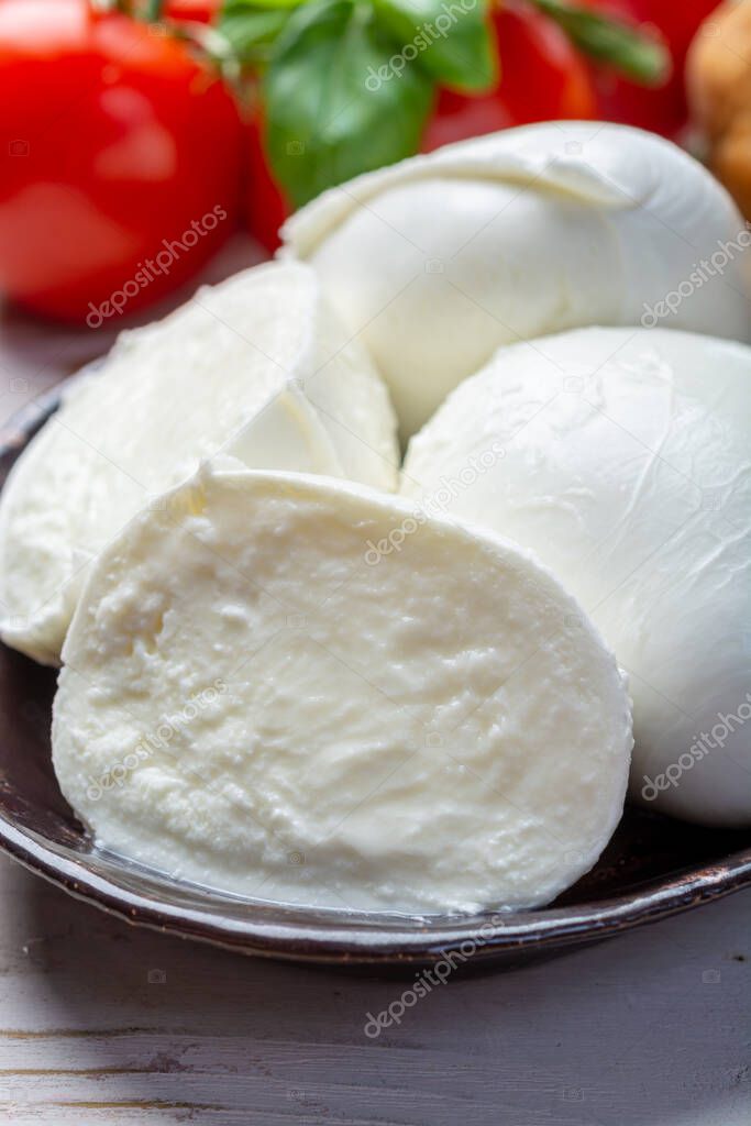 Balls and pieces of buffalo mozzarella, soft Italian scheese made from the milk of Italian Mediterranean buffalo close up