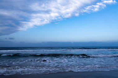 Mavi deniz suyu dalgaları ve kumlu sahil, deniz manzarası