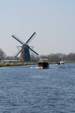 Kuzey Hollanda 'daki su yolları ve kanallar geleneksel Hollanda değirmeni ve bahar manzaralı
