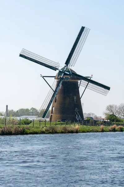 Traditional Dutch wind mill built along canal in North Holland, spring landscape