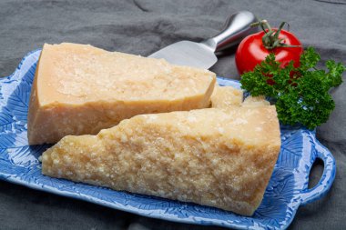Peynir koleksiyonu, İtalyan parmesan peyniri. Mavi tahtada iki parça halinde servis edilmiş. Bıçakla yakından.