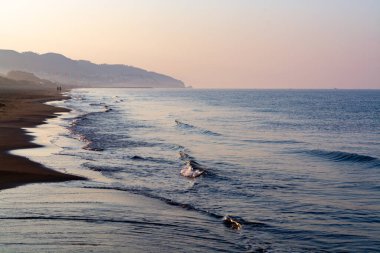 Seascape, sabahın erken saatlerinde Sperlonga ve Terracina, Lazio, İtalya 'nın kumlu sahilleri yakınlarındaki Tyrhenian Denizi üzerinde gün doğumunda.