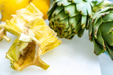 Enginar tarlasından taze taze çiğ enginar başlarının hazırlanması, Yunanistan 'ın Argolida kentindeki yeni hasat, taze limonla pişirmeye hazır.