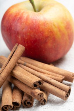 Kış pastası malzemeleri, kurutulmuş aromatik tarçın çubukları ve teneke tabakta elma.