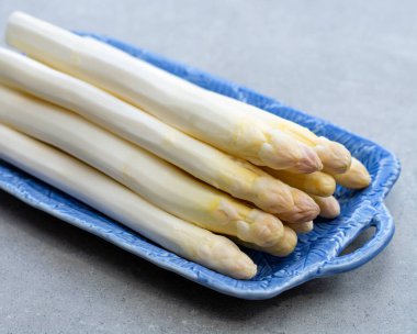 Taze çiğ yıkanmış ve soyulmuş beyaz kuşkonmaz pişirmeye hazır.