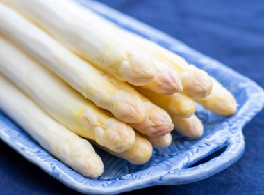 Taze çiğ yıkanmış ve soyulmuş beyaz kuşkonmaz pişirmeye hazır.