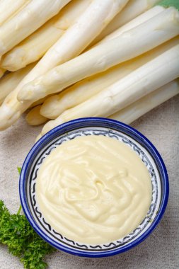 Bir demet taze pişmemiş kuşkonmaz ve kâsede Hollandaise sosu, lezzetli vejetaryen yemeği.