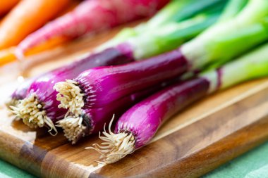 Bir demet taze mor soğan, kırmızı turp ve havuç, yeni sağlıklı sebze hasadı yakın çekim