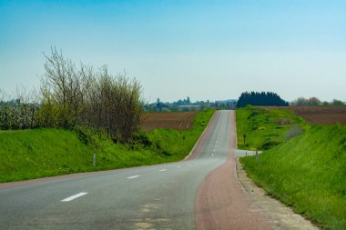 Asfalt yolu ve bahar manzarası çiftçilerin sürdüğü tarlalar ve yeşil çimenler, doğa arka planı