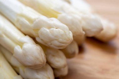 Bahar mevsiminde yeni beyaz kuşkonmaz hasadı. Yıkanmaya hazır beyaz kuşkonmaz. Restoranlar için bahar menüsü.