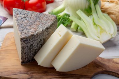 İtalyan peyniri, olgun Toskana Pecorino koyun peyniri ve zeytinli ve domatesli Provolone Dolce inek peyniri.