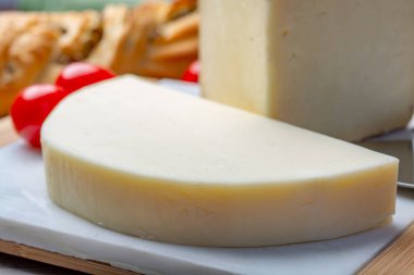 İtalyan peyniri, olgun Toskana Pecorino koyun peyniri ve zeytinli ve domatesli Provolone Dolce inek peyniri.