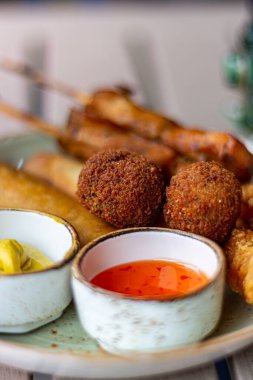 Bira ve şarap için Hollanda atıştırmalıkları, tempura karidesleri, şiş tavuk, acı toplar ve sıcak sos makrosu.