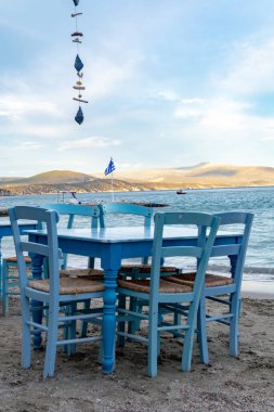 Suyun yakınındaki kumlu kumsalda turistleri bekleyen geleneksel Yunan tavernası Tolo, Moreloponese, Yunanistan 'da tatil sezonu başlıyor