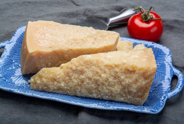 Peynir koleksiyonu, İtalyan parmesan peyniri. Mavi tahtada iki parça halinde servis edilmiş. Bıçakla yakından.