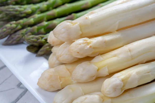 New harvest of white and green asparagus vegetable in spring season, washed asparagus ready to cook, spring menu for restaurants close up