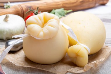 Cheese collection, Italian provolone or provola caciocavallo hard cheeses in teardrop form served on old paper close up clipart