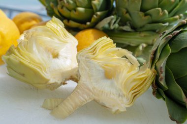 Enginar tarlasından taze taze çiğ enginar başlarının hazırlanması, Yunanistan 'ın Argolida kentindeki yeni hasat, taze limonla pişirmeye hazır.