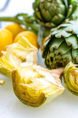 Enginar tarlasından taze taze çiğ enginar başlarının hazırlanması, Yunanistan 'ın Argolida kentindeki yeni hasat, taze limonla pişirmeye hazır.