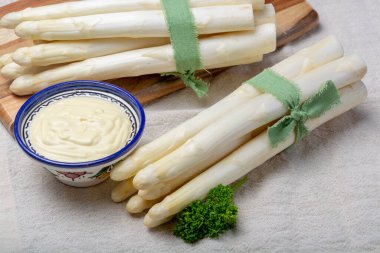 Bir demet taze pişmemiş kuşkonmaz ve kâsede Hollandaise sosu, lezzetli vejetaryen yemeği.