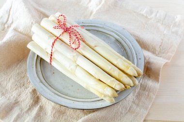 Yeni beyaz kuşkonmaz hasadı sebze, bahar mevsiminde yüksek kaliteli çiğ kuşkonmaz, yakın pişirmeye hazır.