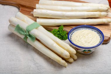 Bir demet taze pişmemiş kuşkonmaz ve kâsede Hollandaise sosu, lezzetli vejetaryen yemeği.