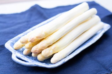 Taze çiğ yıkanmış ve soyulmuş beyaz kuşkonmaz pişirmeye hazır.