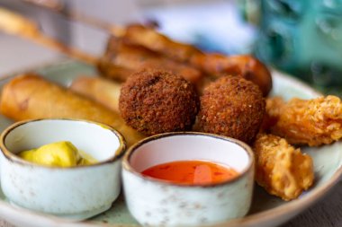 Bira ve şarap için Hollanda atıştırmalıkları, tempura karidesleri, şiş tavuk, acı toplar ve sıcak sos makrosu.