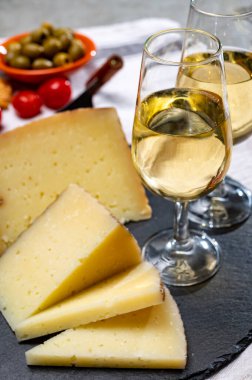 İspanyol İspanyol tapası, manchego peyniri, yeşil zeytin bardakta sek fino şeri şarabı. Yakın plan.