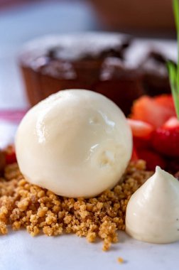 Lezzetli tatlı, sıcak çikolatalı pasta ve taze çilekli vanilyalı dondurma.