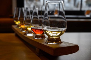 Flight of Scottish whisky, tasting glasses with variety of single malts or blended whiskey spirits on distillery tour in Scotland, UK clipart