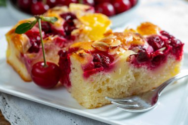 Taze pişmiş kek ve kırmızı sulu ekşi kiraz veya kriek meyveli yakın çekim.