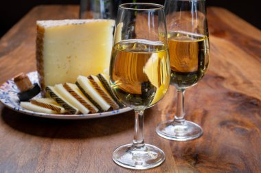 Spanish fino dry sherry wine from Andalusia and pieces of different sheep hard manchego cheeses made in La Mancha, Spain. Wine and cheese pairing clipart
