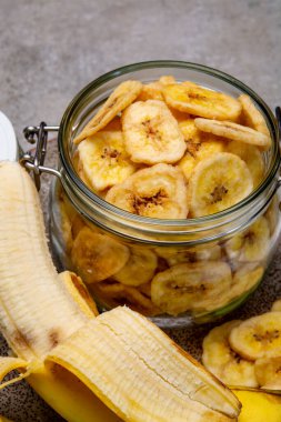 Sağlıklı tatlı atıştırmalık, gevrek, susuz, şekersiz, cam kavanozda muz cipsi.
