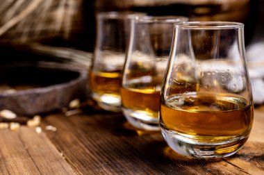 Speyside viskisi. Arpa tanecikli eski siyah ahşap şarap masasında tadıyor.
