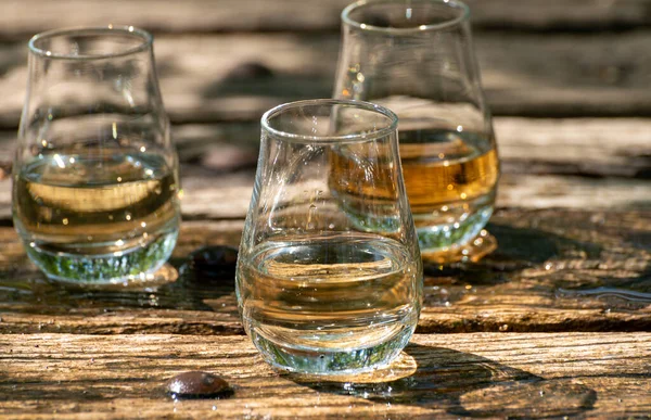 Tasting of different Scotch whiskies on outdoor terrace, dram of whiskey close up