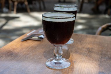 Soğuk koyu Belçika manastırı biralı bardaklar açık havada servis edilir.