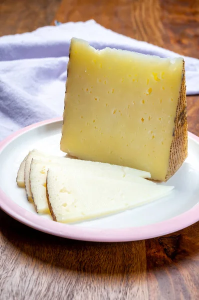 チーズコレクション スペインのラ マンチャで作られたさまざまな羊のハードマンチェゴチーズがホワイトボードでクローズアップされています — ストック写真