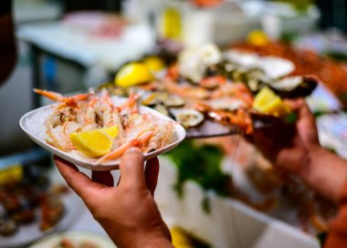 Günün avı, Terracina, İtalya 'daki balık restoranında taze karidesli garson ve buzlu deniz yiyeceği.