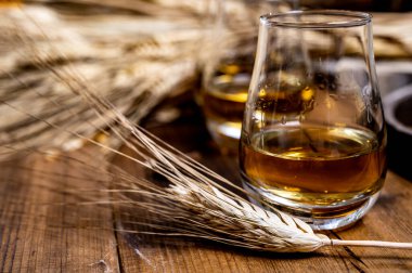 Speyside viskisi. Arpa tanecikli eski siyah ahşap şarap masasında tadıyor.