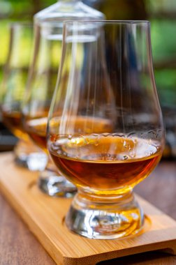 Geleneksel, ahşap pencereli İngiliz evinde farklı viski içecekleri tatmak.