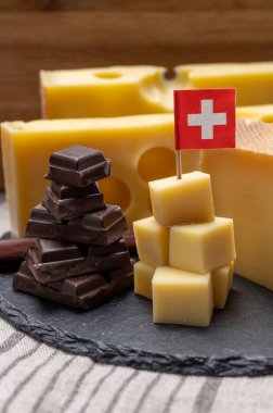 Lezzetli İsviçre yemeği, orta sert sarı peynir bloğu ya da yuvarlak delikli, olgunlaşmış gruyere ve yüksek kaliteli sütlü çikolata, dağların tepesinde İsviçre bayrağı ile servis ediliyor..