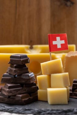 Lezzetli İsviçre yemeği, orta sert sarı peynir bloğu ya da yuvarlak delikli, olgunlaşmış gruyere ve yüksek kaliteli sütlü çikolata, dağların tepesinde İsviçre bayrağı ile servis ediliyor..