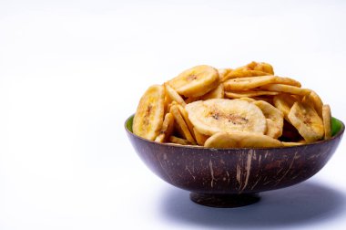 Sağlıklı tatlı atıştırmalık, kıtır kıtır susuz, şekersiz muz cipsi beyaz arka planda kasede.