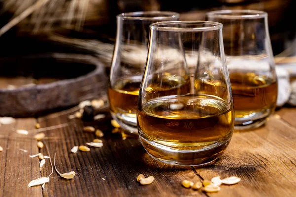 Speyside viskisi. Arpa tanecikli eski siyah ahşap şarap masasında tadıyor.